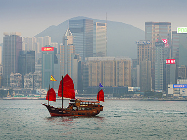 Junk with red sails, with Hong Kong Island waterfront behind, Hong Kong, China, Asia