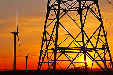 Windmills, pylon and power lines in morning light, Germany, Europe