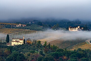 Castello di Gabbiano across a misty valley, church in foreground, San Casciano, Tuscany, Italy, Europe