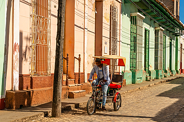 Bicycle buggy named Ferrari going down a cobblestone street, Trinidad, Cuba