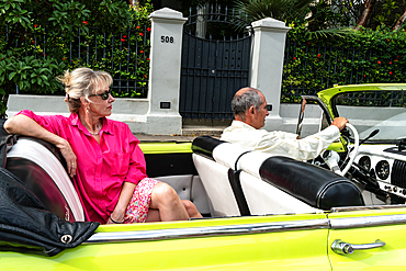 Attractive female Western tourist being driven around in open top Chevrolet classic car, Havana, Cuba, West Indies, Caribbean, Central America