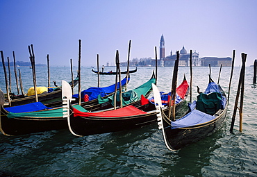 View past docked gondolas towards St.Mark's Square, from across the Grand Canal, Venice, Veneto, Italy 