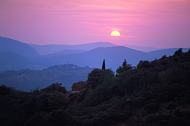 View of Tuscan hill top town with setting sun, Tuscany, Italy, Europe