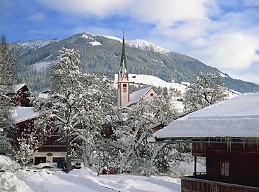 Snow covers the village and church of Alpbach in the Tyrol in the winter, Austria, Europe