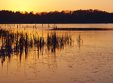 Sunset over frozen Frensham Pond, Frensham, Surrey England, UK, Europe