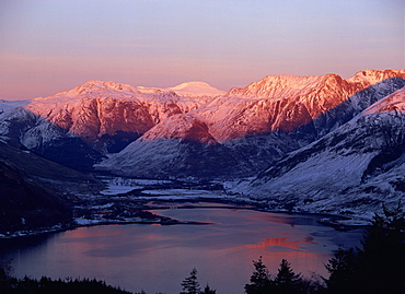 Mountains and Loch Duich head at dusk, with pink light on the snow reflected in water of the lake, from Bealach Ratagain viewpoint, Ratagain Pass, Highlands, Scotland, UK, Europe