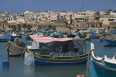 Brightly coloured fishing boats called Luzzus at the fishing village of Marsaxlokk, Malta, Mediterranean, Europe