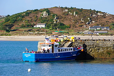 Travellers boarding boat at New Grimsby Quay on Tresco with Bryher in background, Isles of Scilly, England, United Kingdom, Europe