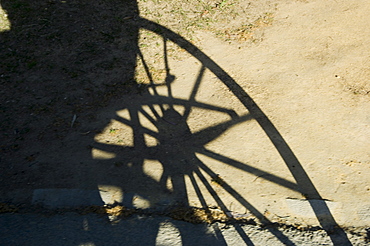 Shadow of horse carriage wheel in Santa Cruz district, Seville, Andalusia (Andalucia), Spain, Europe