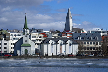 View over Tjornin (pond) to church and Cathedral, Reykjavik, Iceland, Polar Regions