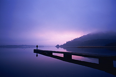 Setting sun through rising mist, Bassenthwaite Lake, Lake District, Cumbria, England, United Kingdom, Europe