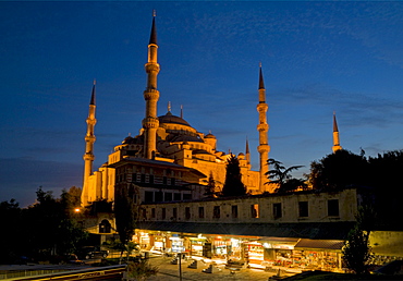 Domes and minarets of the Blue Mosque (Sultan Ahmet Camii), and stalls of the Arasta Carsisi (the Cavalry Bazaar) selling carpets and souvenirs floodlit at night, Sultanahmet, central Istanbul, Turkey, Europe