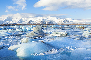 Mountains behind the icebergs locked in the frozen water of Jokulsarlon Iceberg Lagoon, Jokulsarlon, South East Iceland, Iceland, Polar Regions