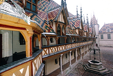 France, Burgondy, Cty Of Beaune, The Medieval Hospital With Varnished Tiles & Gargoyle At Fore On A Hazy Day