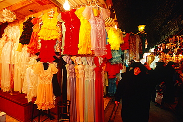 Syria, Aleppo, The Souks (Traditional Covered Markets), Veiled Woman Dressed In Black Passing Female Underwear Stall