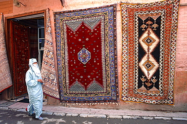 Morocco, Rabat, Medina, Woman Wearing Traditional Veil Passing By A Carpets Dealer