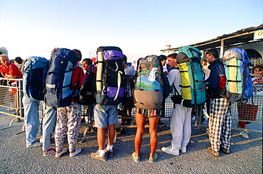 Greece, Cyclades, Mykonos Island, Young Packpackers Just Landed From The Boat Seeking For A Room