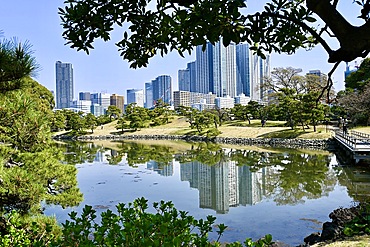 Buildings reflecting on lake in Hamarikyu Gardens