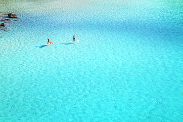 People paddleboarding on the emerald waters of Cala Mitjana, Menorca, Balearic Islands, Spain, Mediterranean, Europe