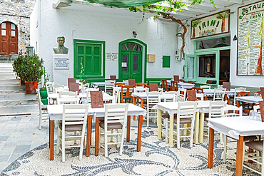 Traditional pebble mosaic adorning Mandraki old town, with cafe chairs and tables, Mandraki, Nisyros Island, Dodecanese Islands, Greek Islands, Greece, Europe