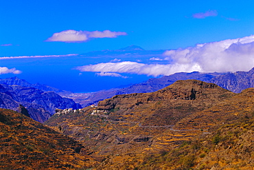 View of coast with Mount Teide in Tenerife in the background, Gran Canaria, Canary Islands, Spain