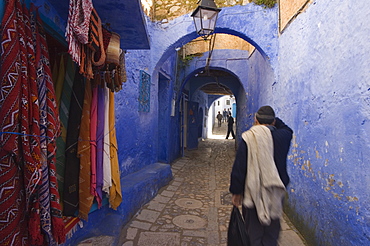 Man walking through pastel coloured streets of Chefchaouen, Morocco, North Africa, Africa