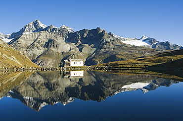 Perfect reflection in lake at Schwarzee Paradise, and small mountain hut, Zermatt Alpine Resort, Valais, Switzerland, Europe