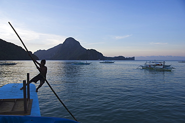 Young boy punting boat, Cadlao Island, Bacuit Bay, El Nido Town, Palawan Province, Philippines, Southeast Asia, Asia