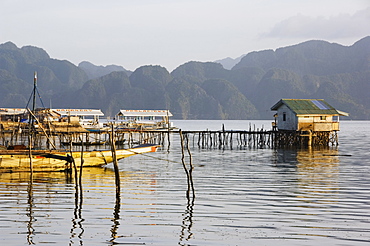 Unusual shaped coastal hills of Coron Island, and stilt houses, Coron Town, Busuanga Island, Palawan Province, Philippines, Southeast Asia, Asia