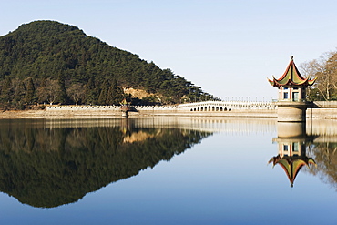 An ancient bridge reflected in the waters of a reservoir at Lushan mountain, UNESCO World Heritage Site, Jiangxi Province, China, Asia