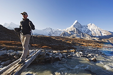 Trekker crossing a mountain stream, Ama Dablam, 6812m, Solu Khumbu Everest Region, Sagarmatha National Park, Himalayas, Nepal, Asia