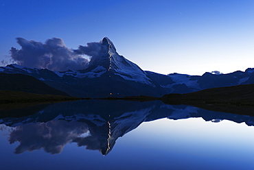 The Matterhorn, 4478m, illuminated in honour of the 150th anniversary of the first ascent, Stellisee lake, Zermatt, Valais, Swiss Alps, Switzerland, Europe