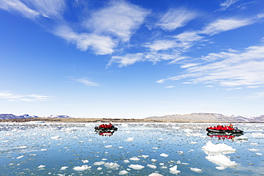 Tourist zodiac in an iceberg filled glacial lagoon, Spitsbergen, Svalbard, Arctic, Norway, Europe