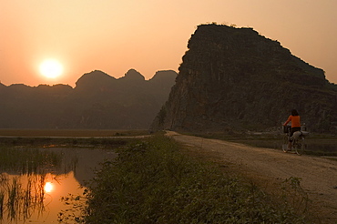 Bicycle in the sunset, limestone mountain scenery, Tam Coc, Ninh Binh, south of Hanoi, North Vietnam, Southeast Asia, Asia