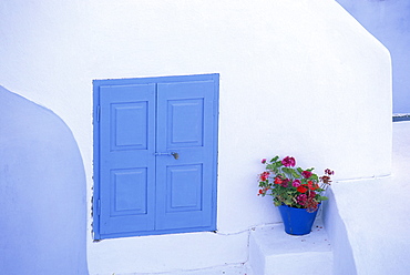 Architectural detail of blue and white house, with pot of geraniums, Oia (Ia), Santorini (Thira), Cyclades Islands, Aegean Sea, Greece, Europe