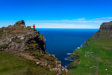 Hiker on The Postman's Trail to the village of Gasaldur, Vagar Island, Faroe Islands, Denmark, Europe