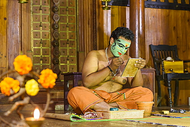 Man applying makeup for Kerala Kathakali performance in Kochi, Kerala, India, Asia