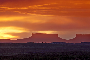 Orange clouds behind a butte at sunset, Canyon Country, Utah, United States of America, North America