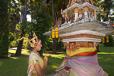 Girl in traditional Thai clothes praying at a spirit house, Phuket, Thailand, Southeast Asia, Asia