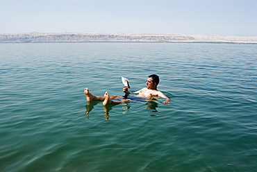 Tourist reading a book, Dead Sea, Jordan, Middle East