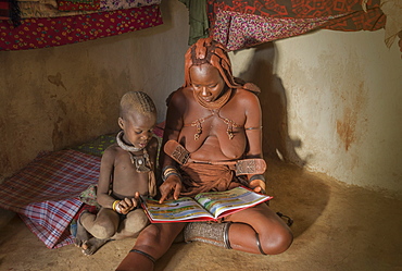 Himba woman and child reading, Kaokoland, Namibia, Africa