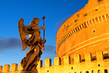 Angel statue on Ponte Sant' Angelo bridge at dusk with Castel Sant' Angelo, Rome, Lazio, Italy, Europe