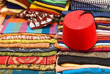 Colourful cotton fabric and a traditional fez for sale in a shop in Luxor, Egypt, North Africa, Africa