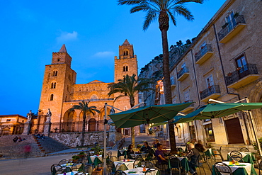 People dining in Piazza Duomo in front of the Norman Cathedral of Cefalu illuminated at night, Cefalu, Sicily, Italy, Europe