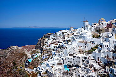 Windmills, houses and hotels in the town of Oia, on the clifftop overlooking the caldera, Santorini, The Cyclades, Aegean Sea, Greek Islands, Greece, Europe