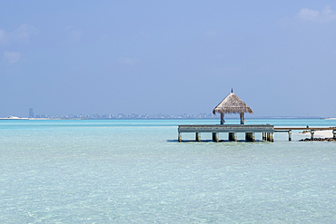 Pier and the clear waters of the lagoon on an exotic Island in the Maldives. Indian Ocean.