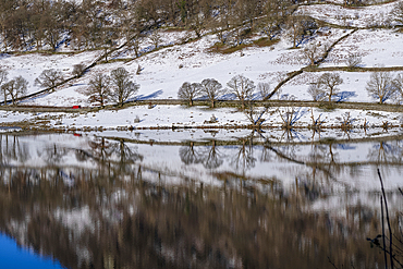 Reflections of snow covered hill at Rydal Water in the Lake District National Park.