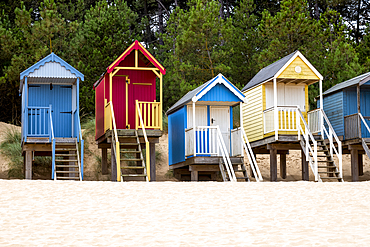 A row of colourful beach huts on the sand at Wells next the Sea in North Norfolk