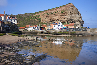 Houses nestled under the high cliffs in the small fishing village of Staithes on the Yorkshire coast.