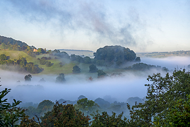 Dramatic mist in the valley below Peak Tor, a distinctive hill near Rowsley in Derbyshire